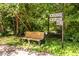 A cozy bench sits under the shade of trees near the street signs for Gaia Gardens at 1001 Dancing Fox Rd, Decatur, GA 30032