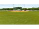 A well-maintained baseball field surrounded by lush green grass and trees creating a serene recreational space at 1974 Skyland Glen Dr, Snellville, GA 30078
