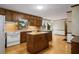 Kitchen featuring wood cabinets, laminate counters, double islands, and hardwood flooring at 1974 Skyland Glen Dr, Snellville, GA 30078