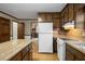 Kitchen with wood cabinets, laminate countertops, white appliances, and hardwood floors at 1974 Skyland Glen Dr, Snellville, GA 30078
