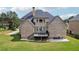 Brick home with a deck and a large backyard with a patio and furniture at 2548 Westchester Se Way, Conyers, GA 30013