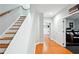 Hallway with hardwood floors leading to media room and stairs with wood handrail at 2548 Westchester Se Way, Conyers, GA 30013
