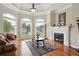 Cozy living room featuring a fireplace, large windows, and hardwood floors at 2548 Westchester Se Way, Conyers, GA 30013