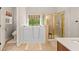 Bright bathroom featuring a walk-in tub, shower, and tile floor at 3633 Gilpin Ct, Lawrenceville, GA 30044