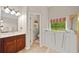 Bright bathroom featuring a walk-in tub, double vanity, shower, and tile floor at 3633 Gilpin Ct, Lawrenceville, GA 30044