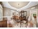 Dining room with tray ceiling, hardwood floors, elegant furniture, and a china cabinet at 3633 Gilpin Ct, Lawrenceville, GA 30044