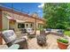 Cozy patio area with comfortable seating, a fire pit, under a pergola with lush landscaping and foliage at 3633 Gilpin Ct, Lawrenceville, GA 30044
