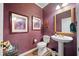 Cozy powder room with pedestal sink, gold-trimmed mirror, and wood-look flooring at 3633 Gilpin Ct, Lawrenceville, GA 30044