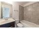 Bathroom features a vanity with a sink and a shower-tub combination with gray tiled walls at 7850 Willoughby Ct, Alpharetta, GA 30005