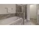 Bathroom features a soaking tub, glass-enclosed shower, and grey tile flooring at 7850 Willoughby Ct, Alpharetta, GA 30005