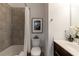 Well-lit bathroom with a shower-tub, framed flower art, and stylish dark vanity at 7850 Willoughby Ct, Alpharetta, GA 30005