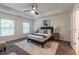 Bright bedroom with tray ceiling, carpeted floor, ceiling fan, and two windows at 7850 Willoughby Ct, Alpharetta, GA 30005
