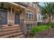 Charming brick townhome entrance with detailed brickwork, iron railings, and lush landscaping at 7850 Willoughby Ct, Alpharetta, GA 30005