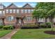 Brick townhome featuring a landscaped front yard and a welcoming entrance with brick steps at 7850 Willoughby Ct, Alpharetta, GA 30005