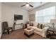Carpeted living room with a white couch, accent chair, mounted TV, and natural light from the window at 7850 Willoughby Ct, Alpharetta, GA 30005