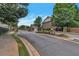 Paved community street leading through a gated neighborhood with trees and manicured landscaping at 7850 Willoughby Ct, Alpharetta, GA 30005