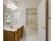 Bright bathroom featuring a single sink vanity with wood cabinets and a tub with a white tile surround at 815 Marshview Close, Roswell, GA 30076