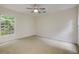 Spacious bedroom featuring neutral walls, carpet flooring, a ceiling fan, and a window that provides natural lighting at 815 Marshview Close, Roswell, GA 30076
