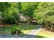Beautiful home nestled among mature trees with a long, private driveway and manicured lawn at 815 Marshview Close, Roswell, GA 30076