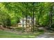 Beautiful home nestled among mature trees with a long, private driveway and manicured lawn at 815 Marshview Close, Roswell, GA 30076