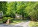 Beautiful home nestled among mature trees with a long, private driveway and manicured lawn at 815 Marshview Close, Roswell, GA 30076