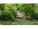 Beautiful home nestled among mature trees with a long, private driveway and manicured lawn at 815 Marshview Close, Roswell, GA 30076
