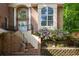 Grand home entrance with brick steps, columns, and arched windows surrounded by lush landscaping at 815 Marshview Close, Roswell, GA 30076