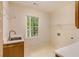 Laundry room with a stainless steel sink, storage, and a window that provides natural lighting at 815 Marshview Close, Roswell, GA 30076