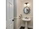 Charming powder room features pedestal sink, decorative mirror, lighting, and paneled walls at 815 Marshview Close, Roswell, GA 30076