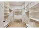 Organized walk-in closet featuring built in shelving, hanging racks, drawers and seating at 815 Marshview Close, Roswell, GA 30076