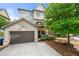 Rear exterior view of home featuring two-car garage, deck, and landscaped yard at 1741 Hickory Path Way, Suwanee, GA 30024