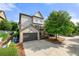 Rear exterior view of home featuring two-car garage, deck, and landscaped yard at 1741 Hickory Path Way, Suwanee, GA 30024