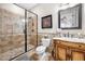 Beautiful bathroom featuring tiled shower with glass door, wooden cabinets, and mosaic tile accents at 1741 Hickory Path Way, Suwanee, GA 30024