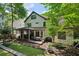 Spacious backyard with a covered patio, outdoor seating, a dining area and lush green landscaping at 2460 Drew Valley Ne Rd, Brookhaven, GA 30319