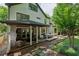 The rear exterior of the home featuring a covered patio, outdoor dining space, and beautifully landscaped backyard at 2460 Drew Valley Ne Rd, Brookhaven, GA 30319