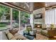 Cozy covered patio with a stone fireplace, comfortable seating, and an outdoor view of the lush backyard at 2460 Drew Valley Ne Rd, Brookhaven, GA 30319