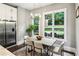Bright dining area featuring stainless steel refrigerator, large windows overlooking the backyard, and modern lighting at 2460 Drew Valley Ne Rd, Brookhaven, GA 30319