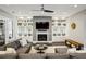 Bright and inviting living room features a fireplace, custom built-ins, and a stylish ceiling fan at 2460 Drew Valley Ne Rd, Brookhaven, GA 30319