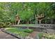 A beautifully landscaped backyard showcases a custom treehouse with multiple levels and play areas for children at 2460 Drew Valley Ne Rd, Brookhaven, GA 30319