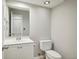 Neutral powder room with toilet, sink, white vanity and updated fixtures at 4710 Vineyard Se Ct, Smyrna, GA 30082