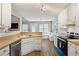 Well-lit kitchen featuring white cabinets, stainless steel appliances, and cozy breakfast nook with ample natural light at 4710 Vineyard Se Ct, Smyrna, GA 30082