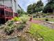 Professionally landscaped backyard features a seating area, lush greenery, and mature trees at 703 Overlook Point, Woodstock, GA 30189