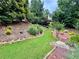 A lush green backyard with mature trees and a cozy seating area at 703 Overlook Point, Woodstock, GA 30189