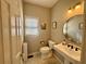 Well-lit half bathroom features pedestal sink, toilet, and window with natural light at 703 Overlook Point, Woodstock, GA 30189