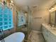 Bright bathroom featuring soaking tub, a glass enclosed shower, and marble countertops at 703 Overlook Point, Woodstock, GA 30189
