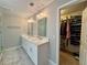 Bright bathroom featuring double vanity with marble countertop, white cabinets, walk-in closet at 703 Overlook Point, Woodstock, GA 30189