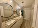 Bathroom featuring double vanity with granite countertop, white cabinets, and a tub at 703 Overlook Point, Woodstock, GA 30189