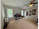 Large carpeted bedroom with a desk, ceiling fan, and natural light at 703 Overlook Point, Woodstock, GA 30189