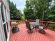 Outdoor deck features a dining table, chairs, and a peaceful view of the surrounding trees at 703 Overlook Point, Woodstock, GA 30189