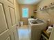 Bright laundry room featuring a white washer, dryer, shelving, and natural light at 703 Overlook Point, Woodstock, GA 30189